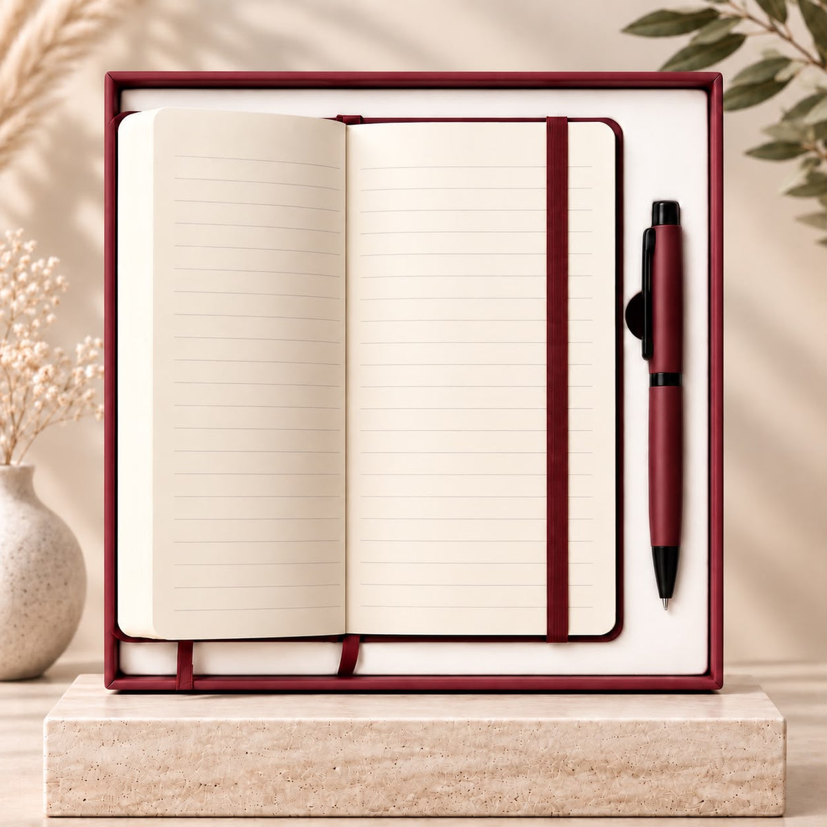 الدفتر العنابي مفتوح مع القلم — Burgundy notebook open with pen